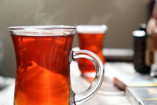 Close-up of steaming Turkish tea in a clear glass showing warmth and relaxation.