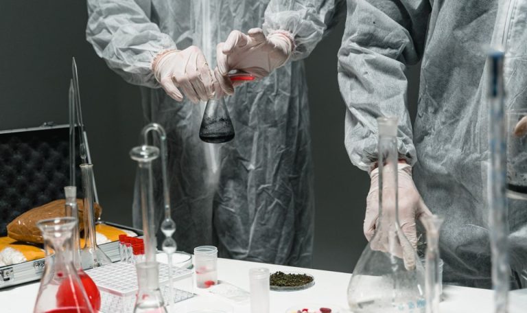 Researchers in protective gear performing experiments in a scientific laboratory.