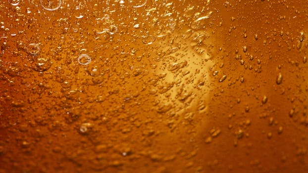 A close-up view of water droplets on an orange surface, showcasing texture and color.